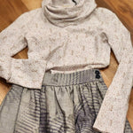 Zero Waste Skirt Gathered Abstract and Leopard print Ruby Jumper laying in a flat lay with the ruby jumper appearing to be tucked into the skirt with one arm bent and resting on the wide waistband of the skirt and the other sleeve laying over the skirt at the side pocket. Two deep blue vintage buttons can be seen on the waistband and the large cowl turtle neck collar of the ruby jumper is in soft focus