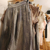 Zero Waste Skirt Gathered Abstract hanging on rack with zero waste tops on wooden coathangers and a wooden rack with a white background. the Australian made skirt has an abstract wave pint and blue and grey coulour palette