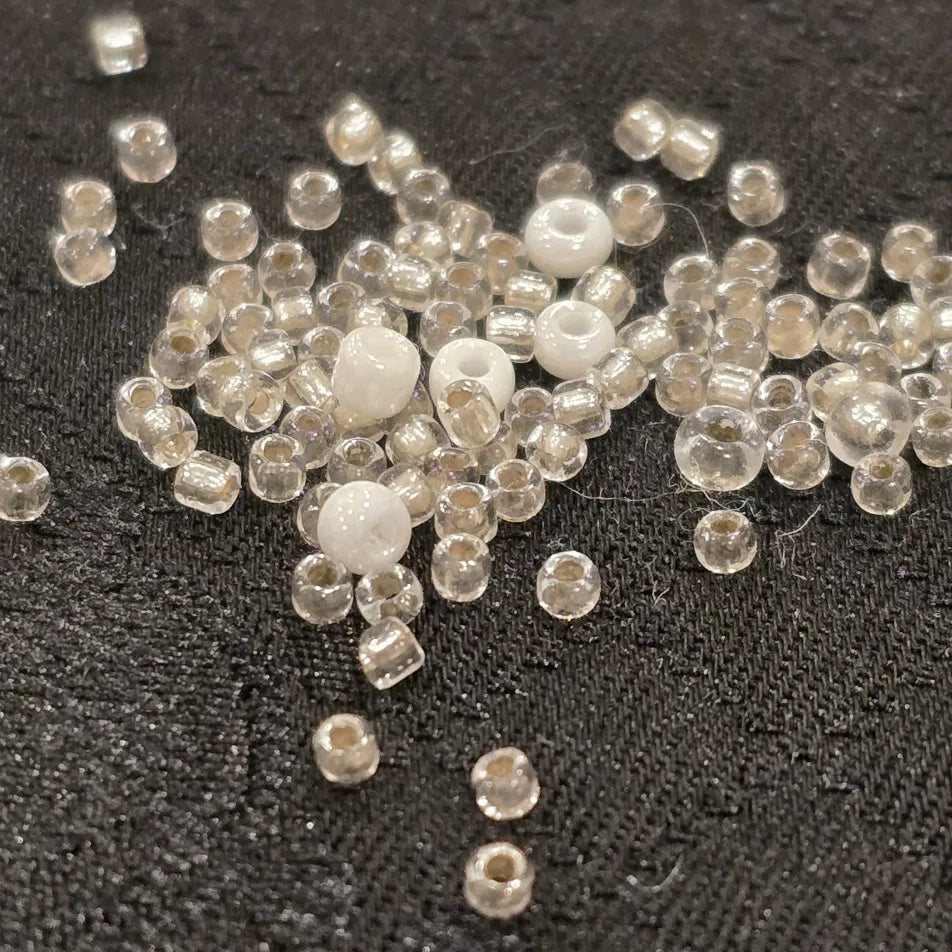 silver and white glass seed beads scattered on a deep black satin wool Japanese Jacquard 
