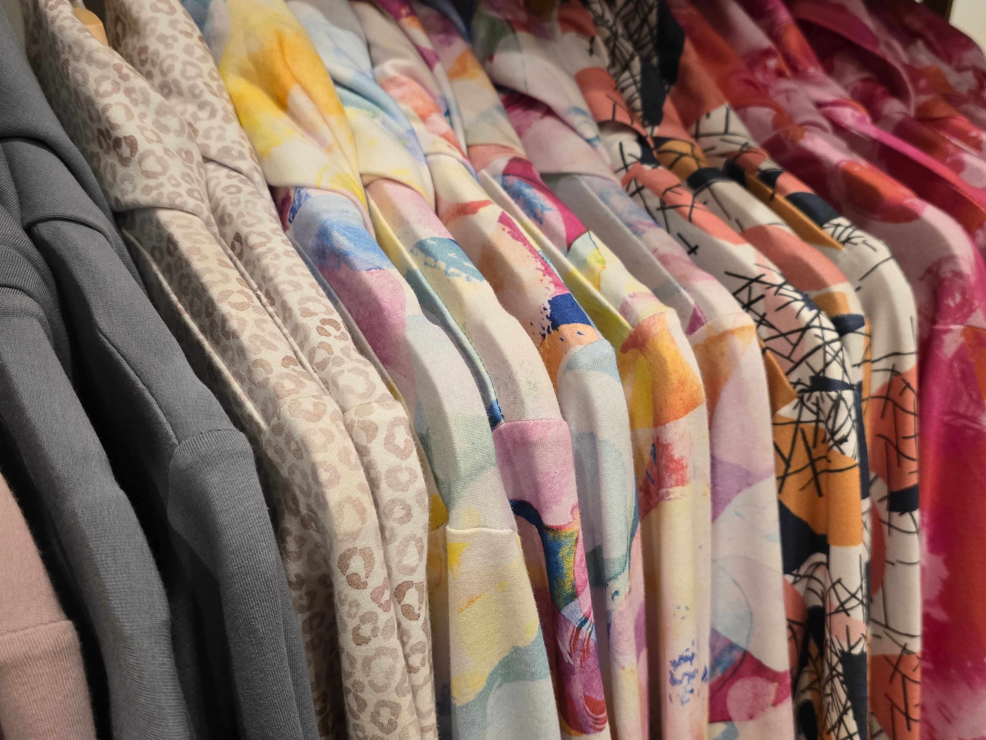 Hanging colourful Ruby Jumpers with long sleeves and extra cuffs. Ethically made and perfect for layering with other pieces for cool weather.