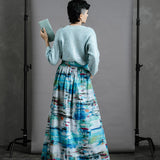 Back view of Model wearing the Ocean Skirt styled with vintage sequinned cardigan and holding a pale blue green  thrifted purse
