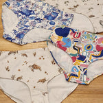 Big Girls Briefs in four different prints laid on a wooden surface.