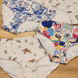 Big Girls Briefs in four different prints laid on a wooden surface.