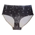 A flat lay of the front of the Night Snow Big Girls briefs on a white background, showing a transitioning black to grey mottled print with white dots that look like large snow flakes, covering the print