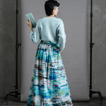 Back view of Model wearing the Zero Waste Ocean Skirt styled with vintage sequinned cardigan and holding a pale blue green  thrifted purse