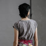 Model wearing the by Audrey and Grace Antique Zero Waste top. She has her back to us, with arms dropped to side and top tucked into the Big Bloom Zero Waste Skirt