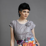 Model wearing the by Audrey and Grace Antique Zero Waste top. We can see the flower detail and the pin tucks and it is worn with the Big Bloom Zero Waste skirt. with models hand in skirt pocket