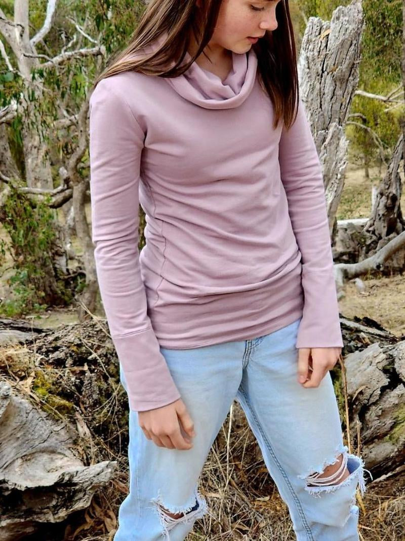 Australian made lavender jumper, The Ruby Jumper, worn by a model who is wearing jeans with torn knees, standing in an Australian bush landscape