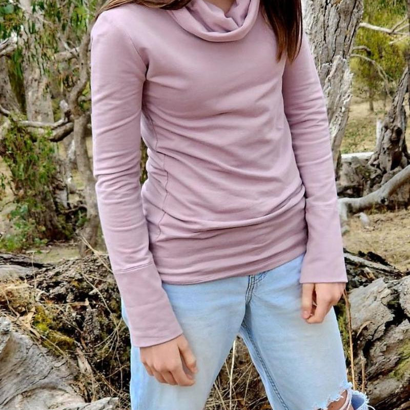 Australian made lavender jumper, The Ruby Jumper, worn by a model who is wearing jeans with torn knees, standing in an Australian bush landscape