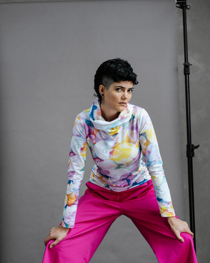 Person wearing the Ruby Jumper Bubbles with pink pants posing against a gray background