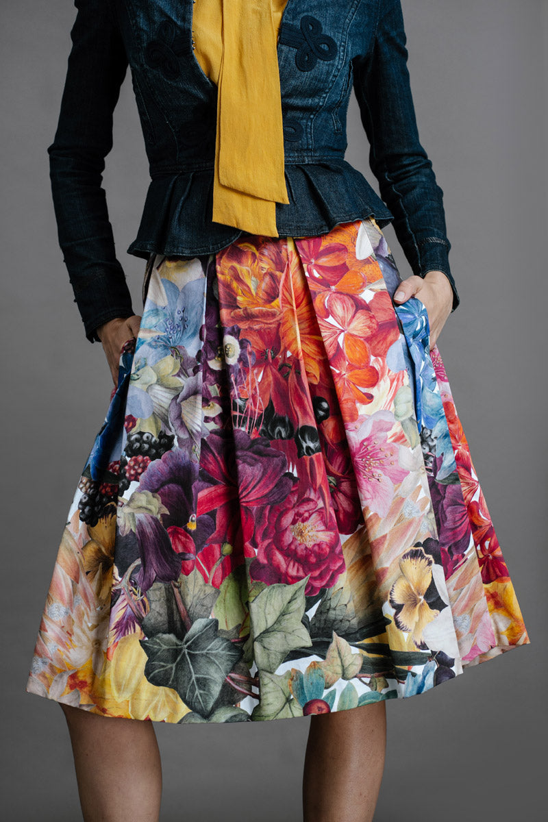 Zero Waste Box Pleat Skirt in Big Bloom, organic cotton — front view on model, styled with fitted denim jacket and mustard blouse, cropped