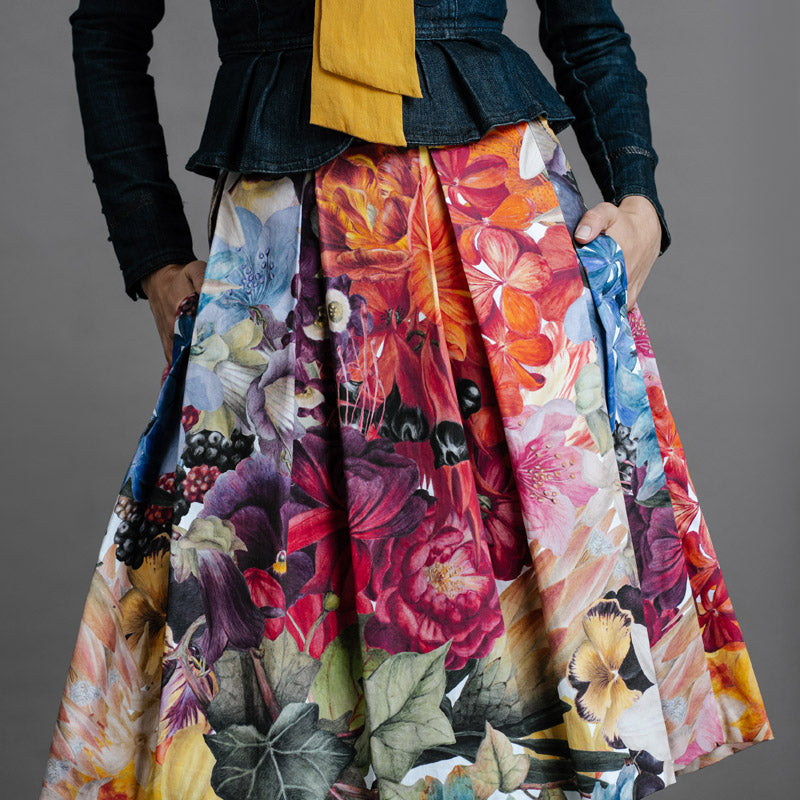 Zero Waste Box Pleat Skirt in Big Bloom, organic cotton — front view on model, styled with fitted denim jacket and mustard blouse, cropped
