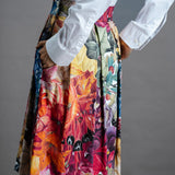 Zero Waste Box Pleat Skirt in Big Bloom, organic cotton — side back view, model has hands in big side pockets and is wearing a white shirt