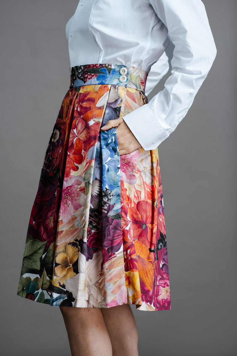 Zero Waste Box Pleat Skirt in Big Bloom, organic cotton — side view, model has hands in big side pockets and is wearing a white shirt