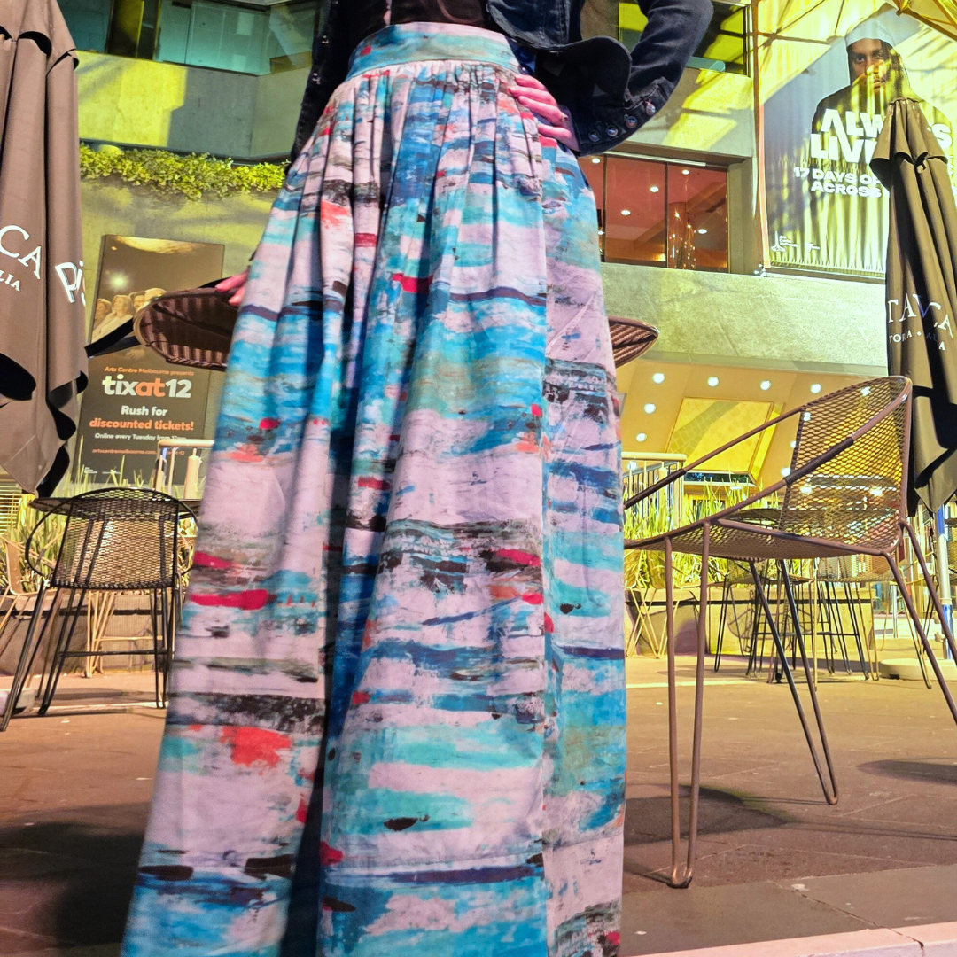 Zero Waste skirt ocean print in blues and turquoise with red, orange and black. Model stands in front of the Melbourne arts centre wearing a piece of Australian designed, Australian made clothing made with a slow fashion model and circular design from organic cotton