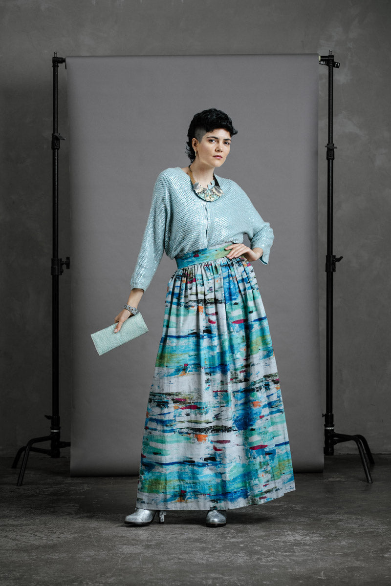 Model wearing full-length Ocean zero waste skirt with vintage beaded cardigan and silver ankle boots, hand on hip