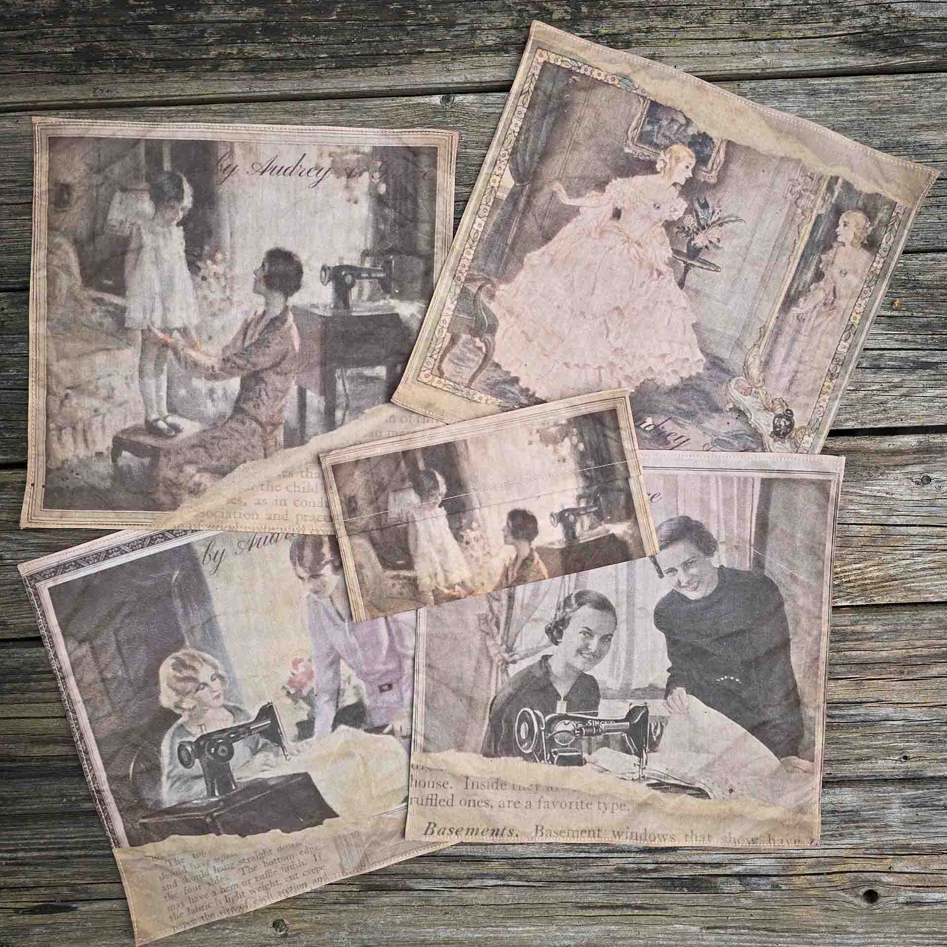 A set of 4 by Audrey and Grace Ladies Handkerchiefs laid out, showing each image. 1 is Mother and child, 2 is The Crinoline Lady, 3 is The lesson with two ladies at the sewing machine and 4 is  Good Taste, showing another two smiling ladies at a sewing machine. All images from the 1920s, with a tear through the image and old type face showing through underneath. They have a small rectangular pouch featuring the Mother and Child print sitting atop of them.