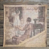 A ladies handkerchief with a special print, depicting a 1920s mother checking the hem length of her littles girls dress as she stands on a stool, with her sewing machine in the background. The imae shows a torn edge with a page of text visible eneath, with an aged feel to the image.