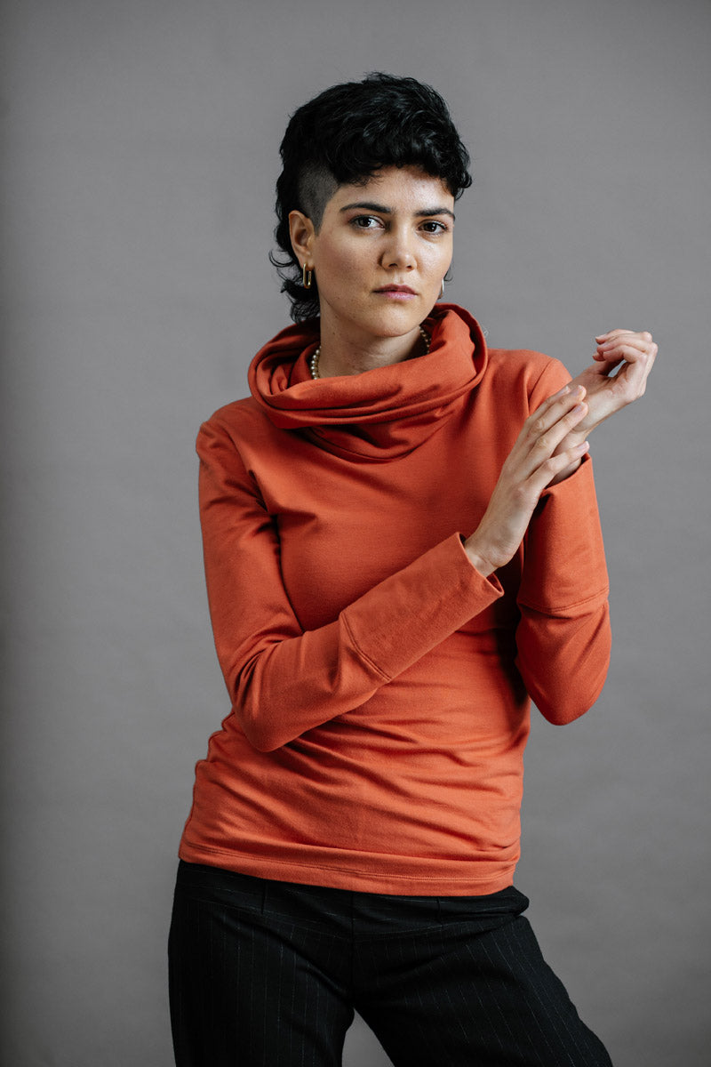 The Ruby Jumper in Terracotta, sustainable and ethical women's jumpers made from Australian cotton — front view with model's hands together and to the side, cropped