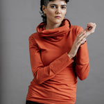 The Ruby Jumper in Terracotta, sustainable and ethical women's jumpers made from Australian cotton — front view with model's hands together and to the side, cropped